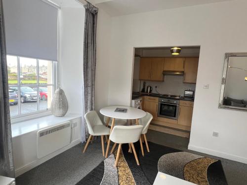 a kitchen with a table and chairs in a room at Ayr Cozy Corner Apartment in Ayr
