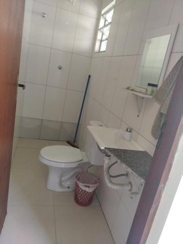 a bathroom with a toilet and a sink and a mirror at Pesqueiro Restaurante e Pousada Pingo de Ouro in Piedade