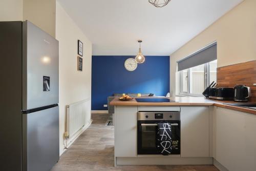 a kitchen with a stove and a counter top at Exceptional 3 bed house with homely comforts, Close to fast food, supermarkets and city centre in Sheffield
