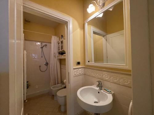 y baño con lavabo, aseo y espejo. en Magenta Apartment, en Florencia