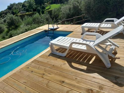 una terraza con tumbonas y una piscina en Casa di campagna in collina, en Tatti