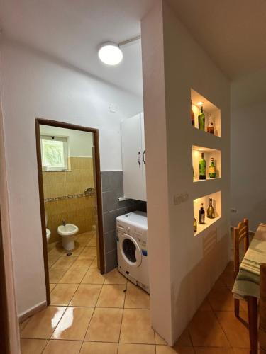 uma casa de banho com máquina de lavar e secar roupa num quarto em Private House Velipoj em Velipojë