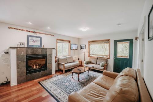 a living room with a couch and a fireplace at 77MBR - Wi-Fi - Fireplace - Pets Ok - BBQ cabin in Glacier