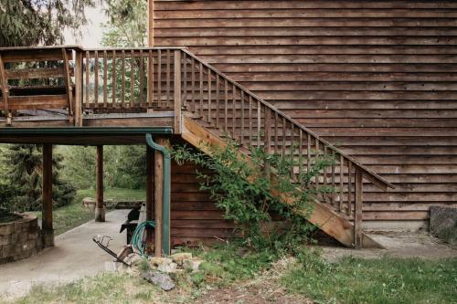 a wooden staircase with a wooden railing next to a house at 77MBR - Wi-Fi - Fireplace - Pets Ok - BBQ cabin in Glacier