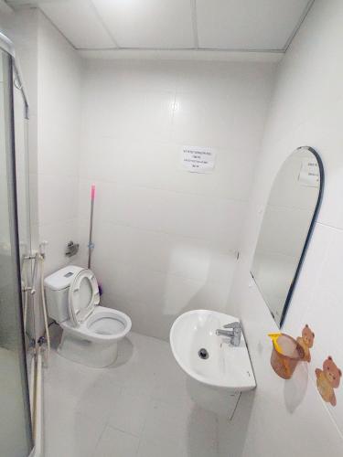 a white bathroom with a toilet and a sink at Long Home 3 in Ho Chi Minh City