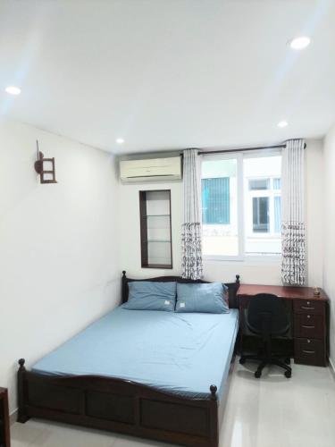 um quarto com uma cama, uma secretária e uma janela em Long Home 3 em Cidade de Ho Chi Minh