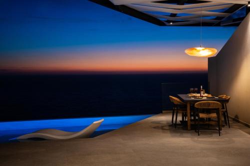 a dining room with a table with a view of the ocean at Aeliades Villas in Agios Nikitas
