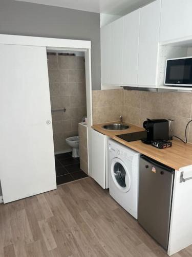 une cuisine avec une machine à laver et un évier dans l'établissement Studio refait à neuf Clichy centre, à Clichy