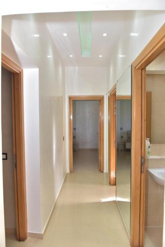 een hal van een badkamer met een wastafel en een spiegel bij Golf Royal appartement in Fès