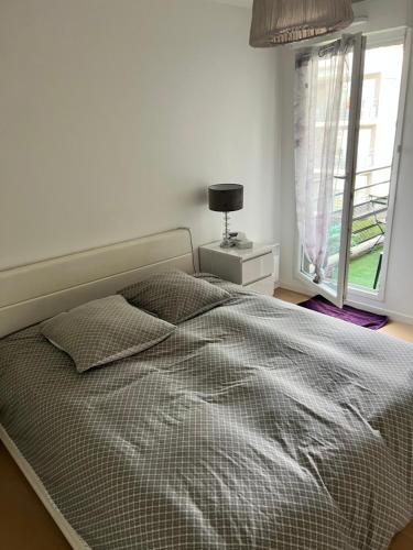 une chambre blanche avec un lit et une fenêtre dans l'établissement appartement 2 pièces 5min gare val d'Europe parking inclus, à Montévrain