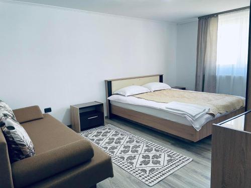 a bedroom with a bed and a couch at Casa Daya Borsa in Statiunea Borsa