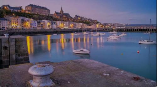 a harbor with boats in the water at night at Gîte à la campagne in Le Mesnil-Villeman