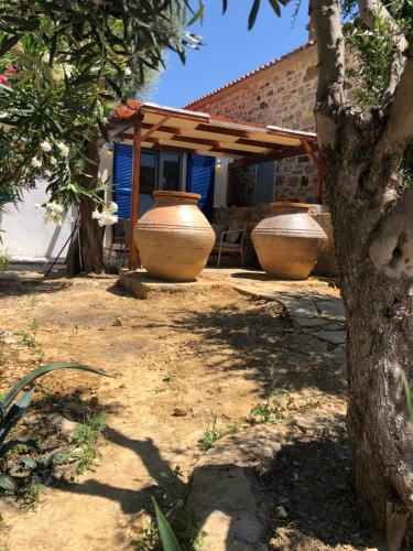 three large vases sitting outside of a house at Quiet Guest house in Moúdhros