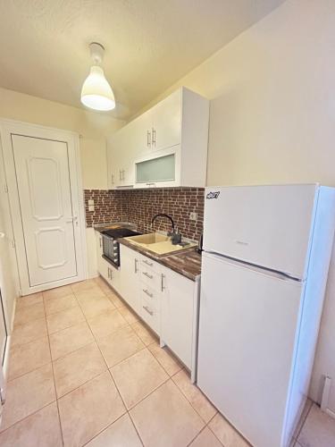a kitchen with white appliances and a white refrigerator at Natura Bungalows-Villa in Limenas