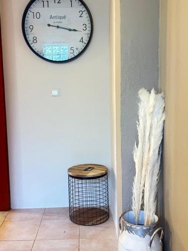 a clock on a wall next to a stool at Natura Bungalows-Villa in Limenas