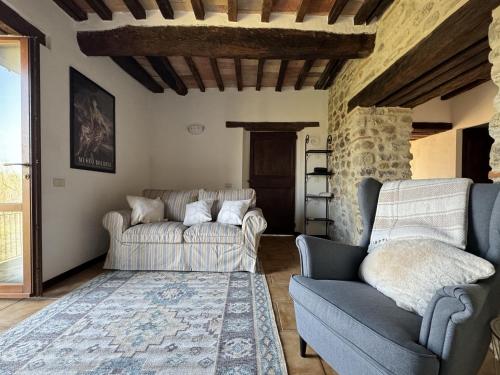una sala de estar con 2 sofás y una alfombra en Casa Montecastelli Sopra/Terra, en Monte Castelli