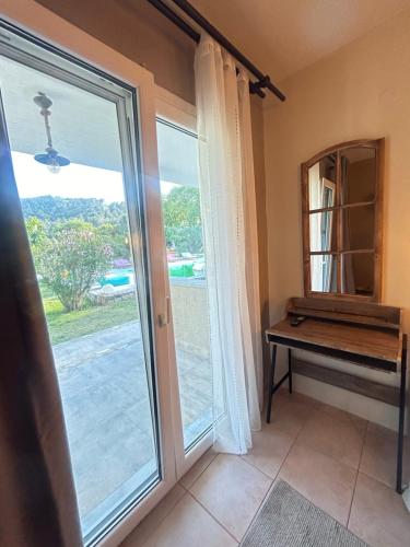 Natura Bungalows في لايميناس: غرفة بها باب زجاجي منزلق ومرآة