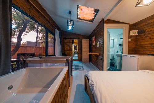 uma casa de banho com uma banheira e uma cama. em KurtköyparkBungalovEvleri em Sakarya