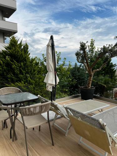 a patio with a table and an umbrella and chairs at Trevi Hotel & Restorant, Shengjin in Shëngjin