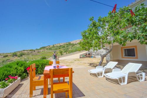 a patio with a table and chairs and a tree at Ante - The View in Metajna