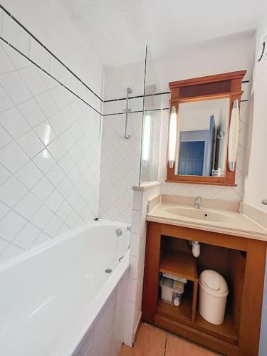 une salle de bain avec une baignoire, un lavabo et un miroir dans l'établissement Appartement à 2 pas océan et lac, à Lacanau