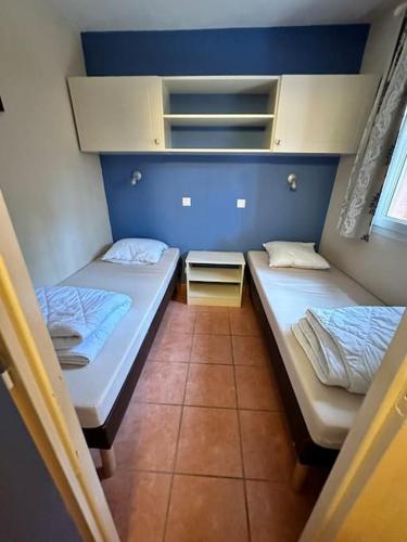 une petite chambre avec deux lits et une fenêtre dans l'établissement Appartement à 2 pas océan et lac, à Lacanau
