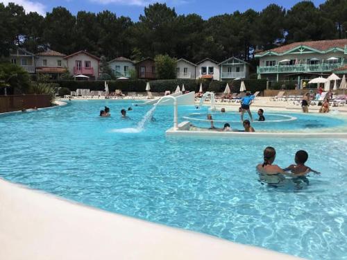 un groupe de personnes dans une piscine dans l'établissement Appartement à 2 pas océan et lac, à Lacanau