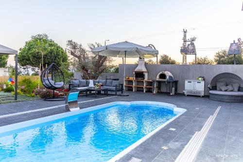 a backyard with a swimming pool and an outdoor grill at אחוזת רוטצ'י - יוקרה בגליל in Safed
