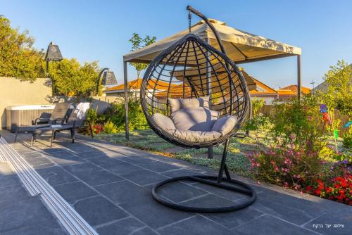 a swing in a garden with a gazebo at אחוזת רוטצ'י - יוקרה בגליל in Safed