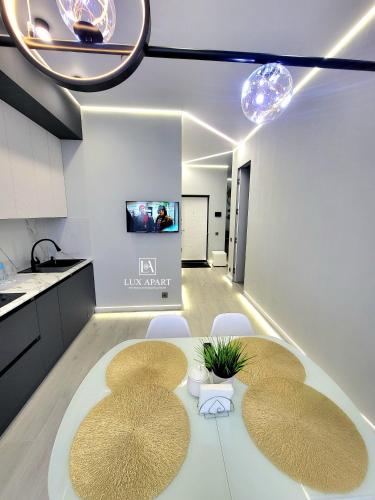 Una cocina con mesa y sillas y un televisor. en Lux апартаменты в новом центре Караганды, en Karagandá