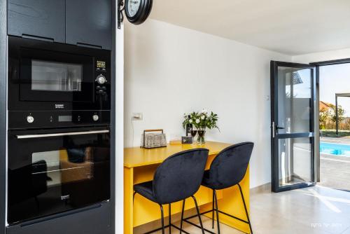 a kitchen with a yellow table and black appliances at אחוזת רוטצ'י - יוקרה בגליל in Safed