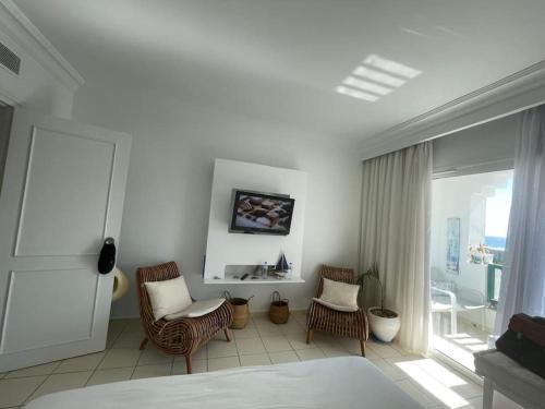 a white room with two chairs and a bed at Appartement Sur La Plage in Hammamet