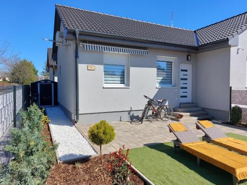 a house with a patio and a bike in the yard at Három Testvér Apartman in Siófok