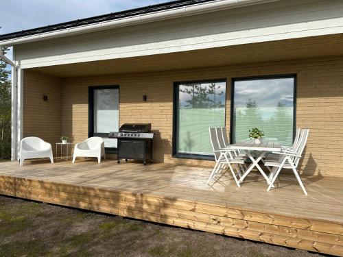 eine Terrasse mit einem Tisch, Stühlen und einem Klavier in der Unterkunft Brand New! Villa Moon in Rovaniemi