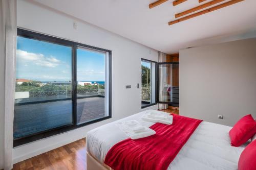 a white bedroom with a large window and a bed at TableTop in São Roque