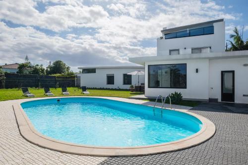 a swimming pool in front of a house at TableTop by Azorean Living in São Roque