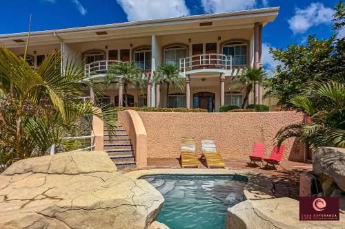 uma casa com piscina e duas espreguiçadeiras em Casa Esperanza SJDS em San Juan del Sur