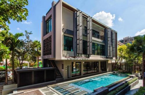 an exterior view of a house with a swimming pool at LIV@5 Condominium in Bangkok