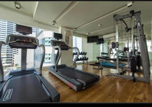 a gym with several tread machines in a room at LIV@5 Condominium in Bangkok
