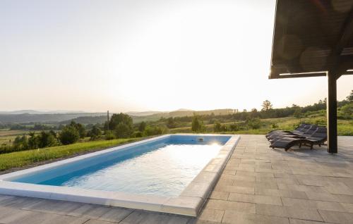 a swimming pool with two benches sitting next to it at Amazing Home In Cetingrad With Wifi in Cetingrad