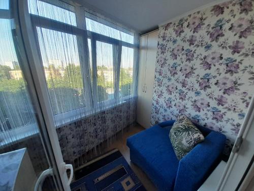 sala de estar con sofá azul y ventana en Апартаменти біля Автовокзалу, en Rivne