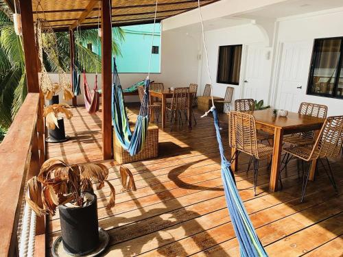 a porch with a hammock and a table and chairs at La Sirenne Inn in El Nido
