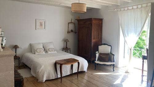 een slaapkamer met een bed, een stoel en een raam bij Mazette! Le Château in Niort
