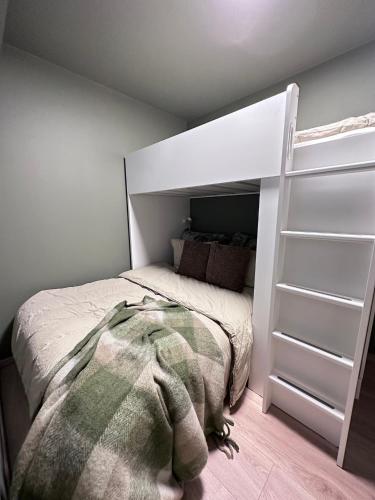 a bedroom with a bed with a green blanket at Årosstranda in Kristiansand