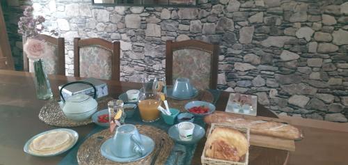 Syb'elle étape في Thury-sous-Clermont: طاولة مع طعام ومشروبات على جدار حجري