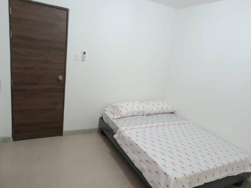 a small bed in a room with a door at Nido de amor Vía a la Costa in Guayaquil