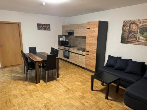 a living room with a table and a couch and a kitchen at Laras voll ausgestattete Gartenwohnung mit WLAN und TV in Werne an der Lippe