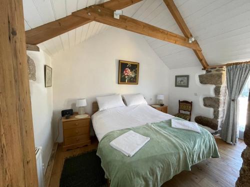 1 dormitorio con 1 cama grande en el ático en Trengothal Barn, en Porthcurno