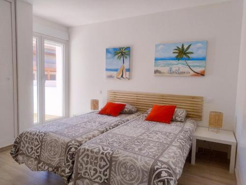 a bedroom with two beds with red pillows at Apartamento Aura in Jávea