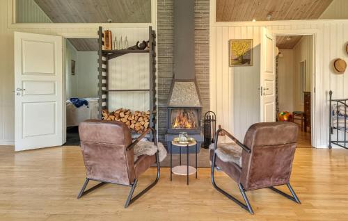 a living room with two chairs and a fire place at Beautiful Home In Henån With Kitchen in Henån